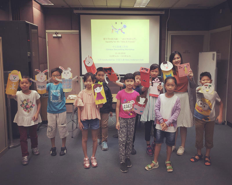 參與中文故事工作坊的小朋友和導師合照，展示手工紙偶，有小兔和高仔等不同角色。
